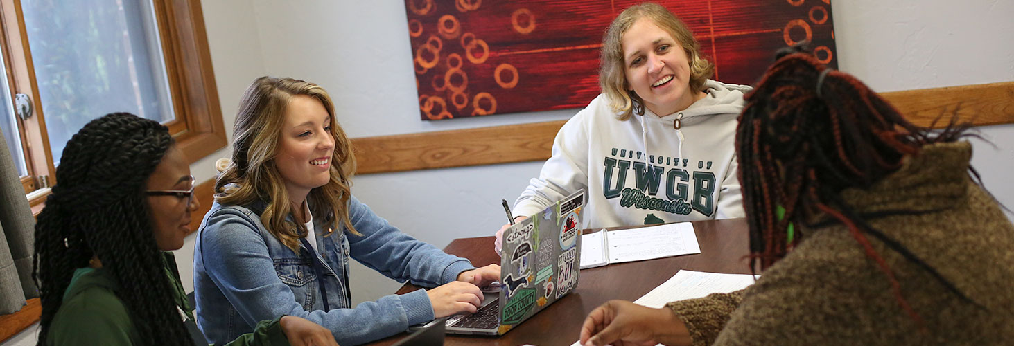 Students having a conservation while studying at a table