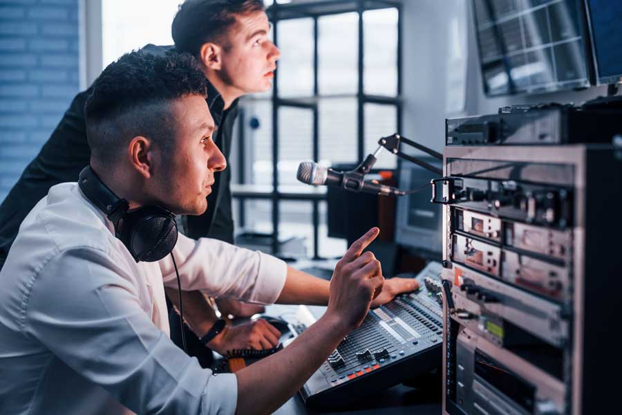 Two male students work together on radio broadcast