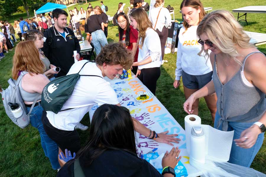 Students at Org Smorg stamp their hand prints onto poster