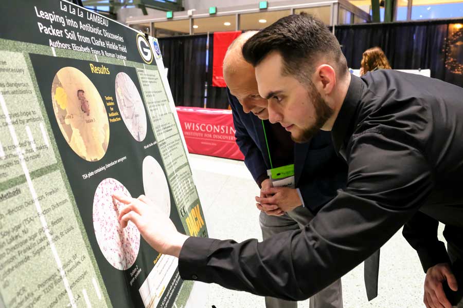 Professor Brian Merkel and student look at Tiny Earth Symposium project