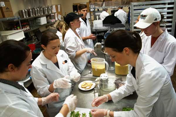 Nutrition students prepare meal in kitchen