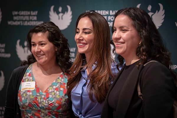 Mariana taking a photo with two attendees
