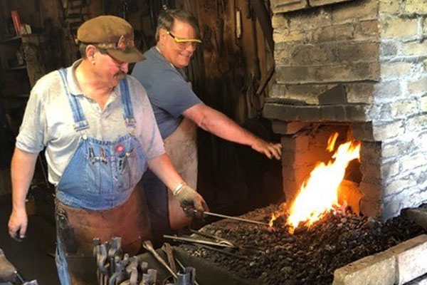 Blacksmith giving a demonstration to a group of people