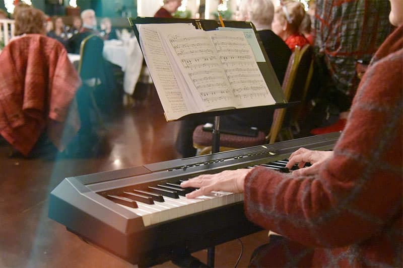 Woman playing keyboard music at the holiday social