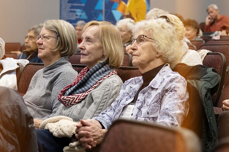 three women listening to a presenter