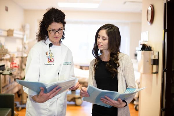 Two nurses looking over charts in clinic