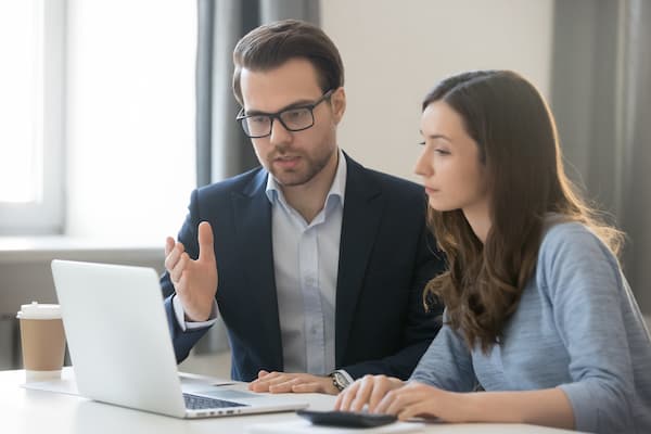 Male and female work together at laptop computer