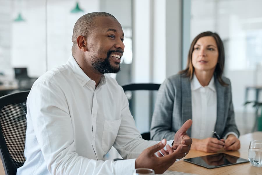 Male and female coworkers engage in a discussion at business meeting