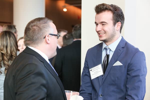 Male student speaks with professor at Business Week event