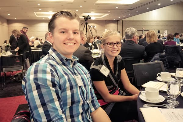 Male and female student pose for photo at management dinner