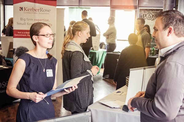 Student speaks to business man at business week networking event