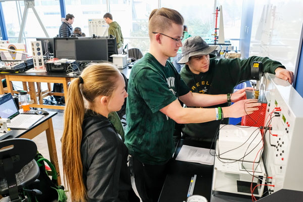 Students perform controls and measurements during Assistant Professor Riaz Ahmed engineering lab