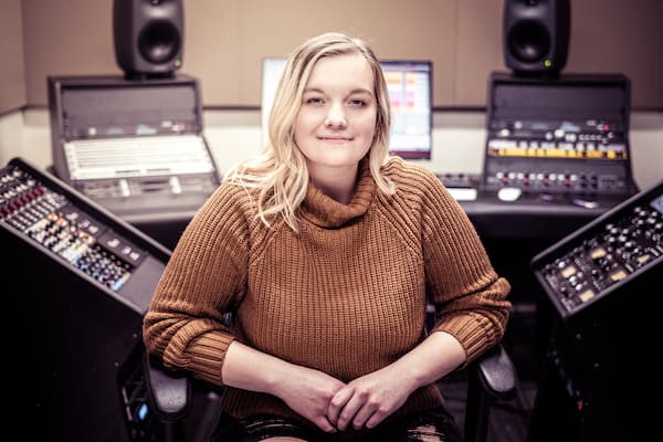 Student poses for photo in music studio