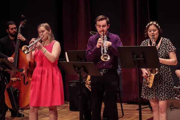 Students play brass instruments in ensemble