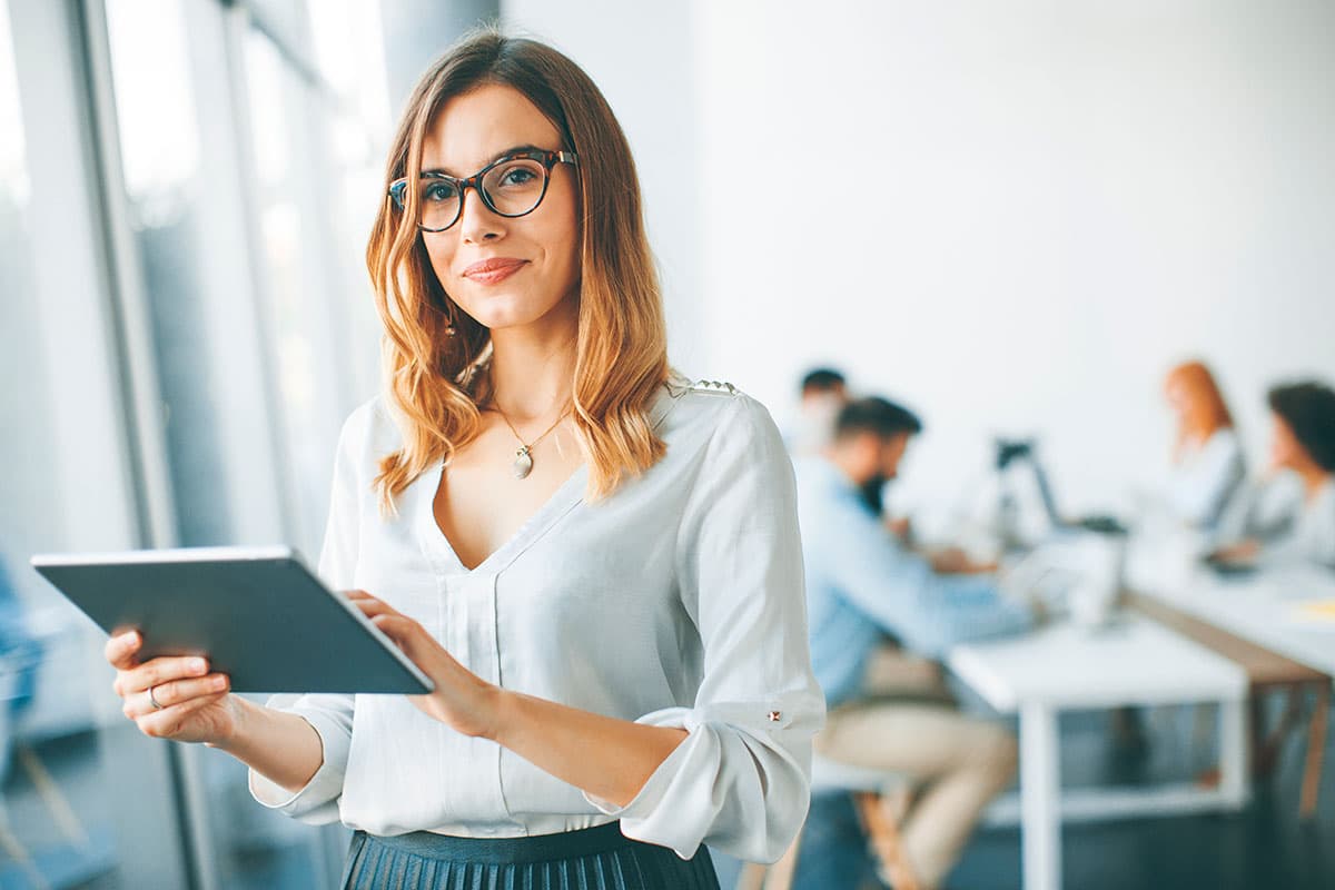 confident businesswoman standing holding digital tablet