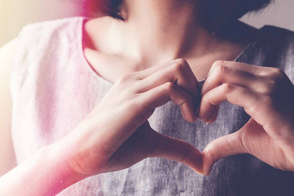 woman making her hands into a heart shape