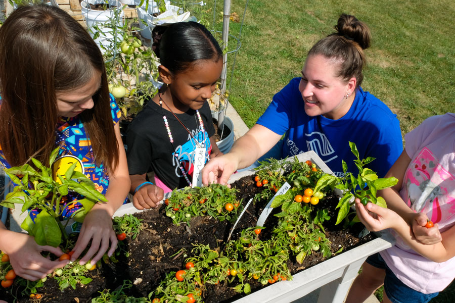 Nutrition and dietetics students teachings gardening to community children