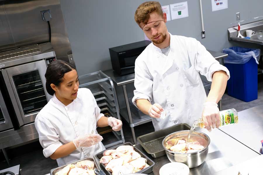 Students prepare chicken in STEM Center kitchen