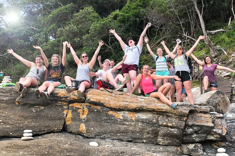 Psych students pose for picture on larges rock in South Africa