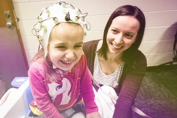 Female student preforms eeg on child