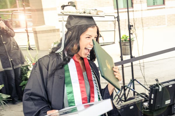 Female student holding diploma and smiling