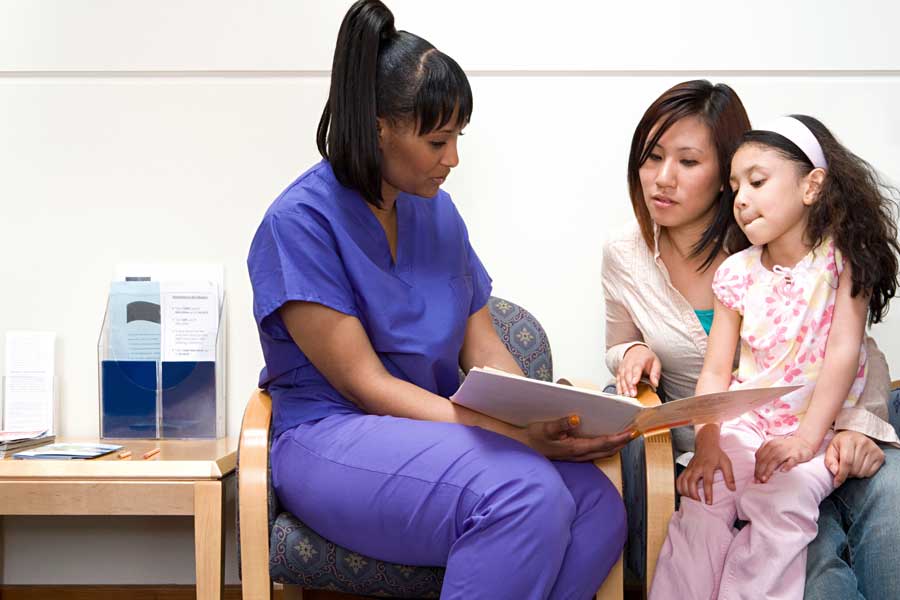 Female nurse speaks with mother and daughter