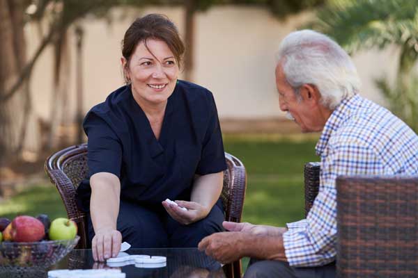 Nurse speaks with elderly patient outdoors