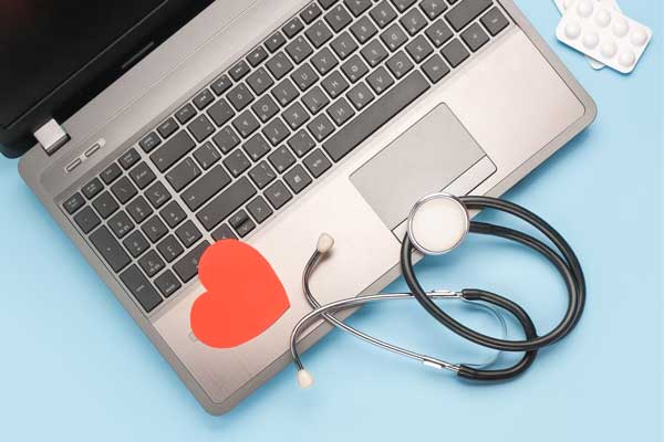 laptop with stethoscope and paper heart