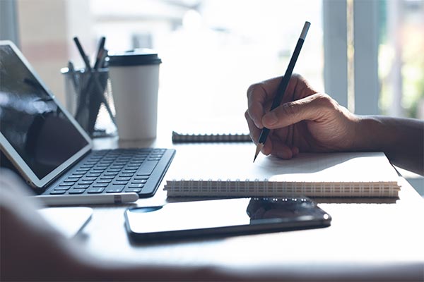 student taking notes during online class