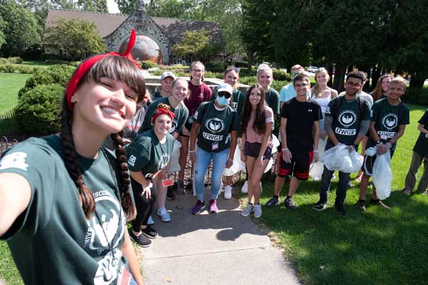 Students wear uwgb t-shirts while posing for photo