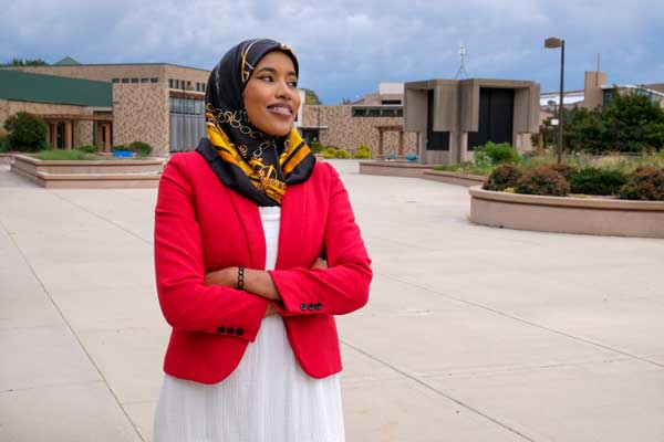 Female student in hijab poses in front of UWGB campus