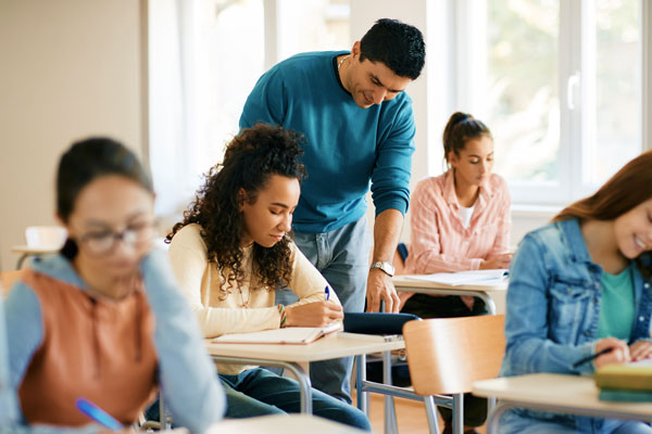 Male teacher working with students in class