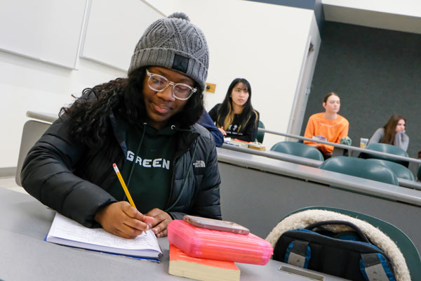 African American student takes notes in class