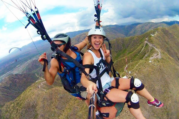 Two students paragliding while studying abroad