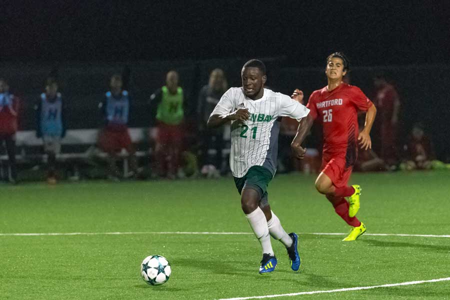 UWGB mens soccer player defends soccer ball