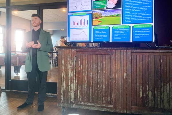 Student presents thesis to peers at end of year gathering