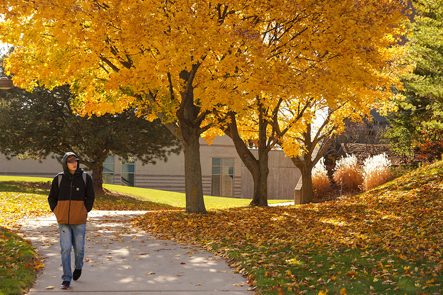 Student walking through the UW-Green Bay quad on a fall day