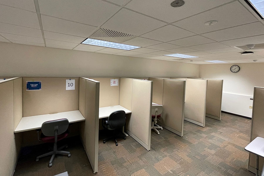 UWGB Testing center is a carpeted space with office chairs and desks with cubicle partitions