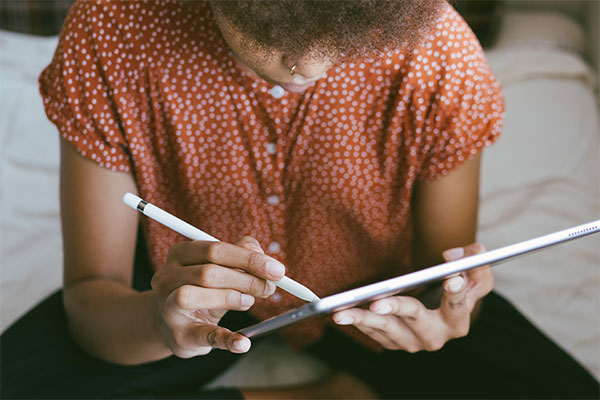 Student using a tabet and stylus to make notes in a digital textbook