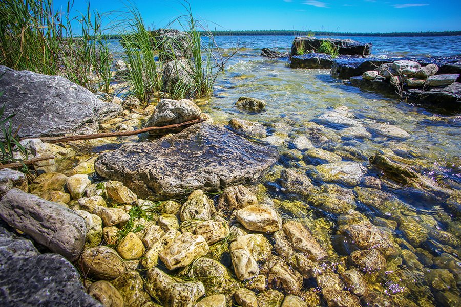 rocks showing at bottom of clear lake water