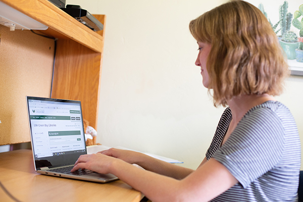 Student using a laptop in her dorm room