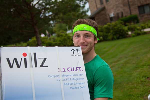 Student carying a micro-fridge at freshman move-in day