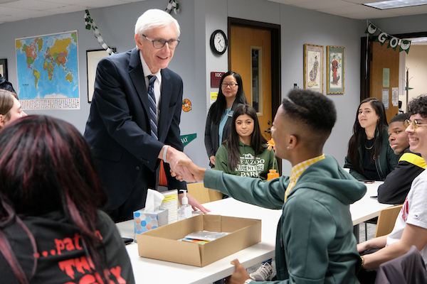 Tony Evers shakes student hand at MESA meeting