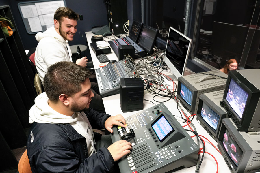 Two male students working in theatre control room
