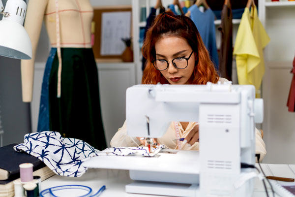 Costume designer works at sewing machine