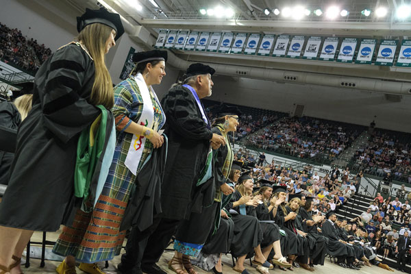 Graduates standing in a row at commencement