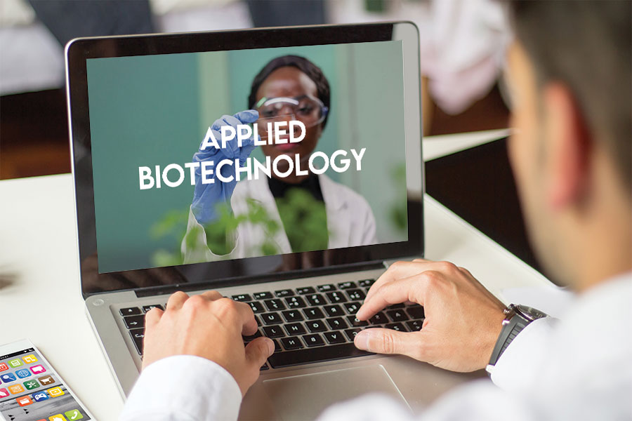 Man working on a laptop with the Applied Biotechnology screen.