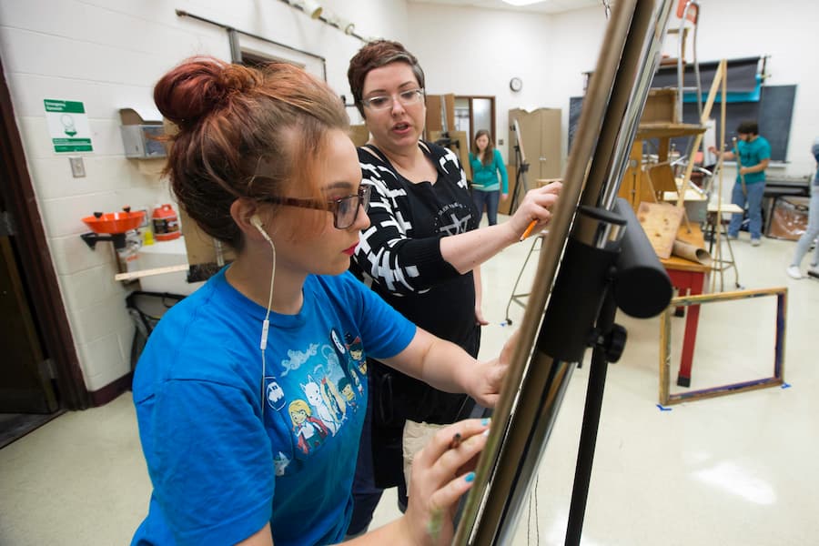 Teacher works with student in drawing studio