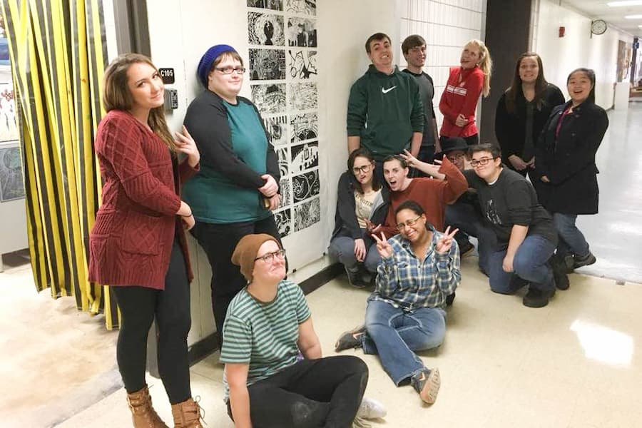 Students pose for photo in art building hallways