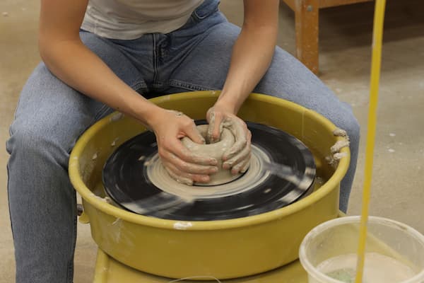 Student throws on potter's wheel